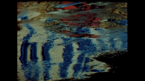 Still from Abstract in Concrete (1952). Director John Arvonio filmed lights reflecting on street puddles, creating the illusion of an oil painting.
